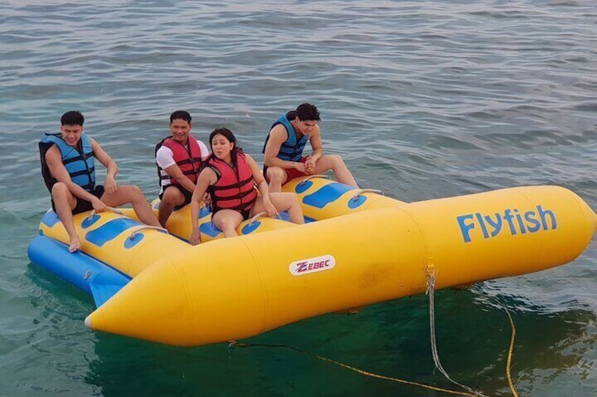A yellow inflatable raft with the word "Flyfish" on it, floating on water. 1