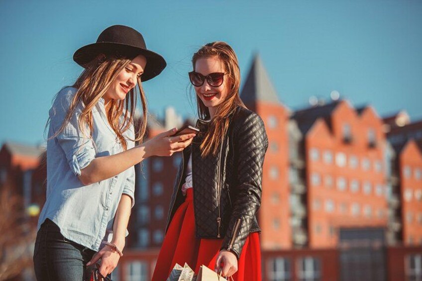 Two people standing outdoors with buildings in the background. 4
