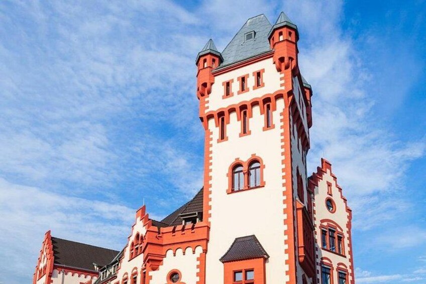 A large, historic building with a prominent tower and red brick facade. 1