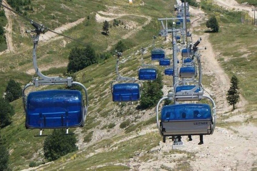 Un sistema di funivia con cabine azzurre su un sentiero di montagna. 4