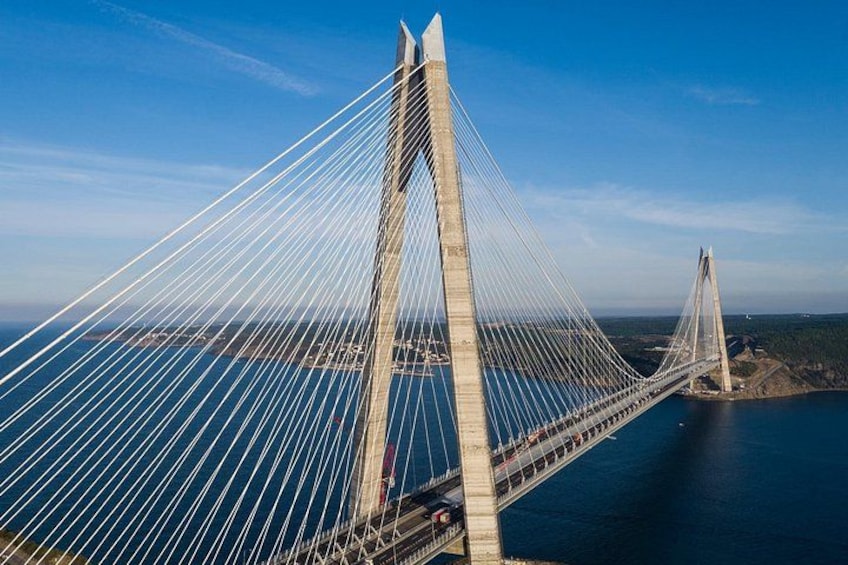 Un ponte strallato con numerosi cavi, cielo sereno e un corpo d'acqua. 5