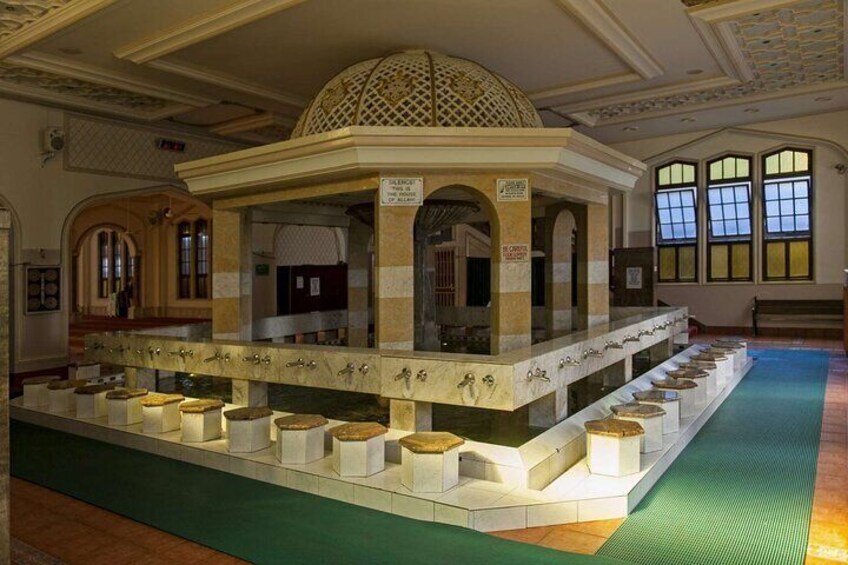 A historical building with a central dome, arched windows, and a long display of artifacts. 3
