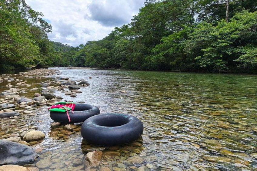 Un río de aguas transparentes, rodeado de rocas y abundante vegetación. 3