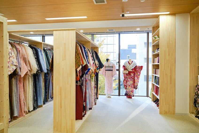 Een kledingwinkel met houten planken en rekken vol kleding. 5