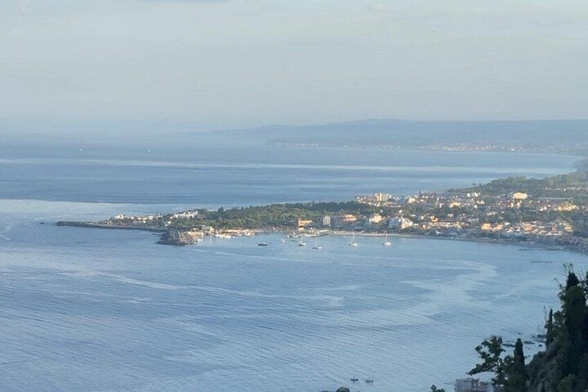 A coastal town with buildings along the shore and boats in the water. 5