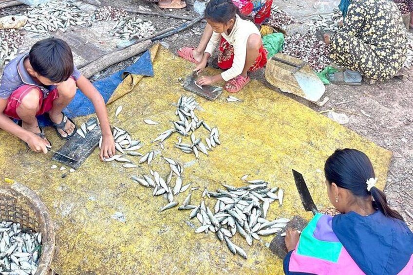 Menschen sortieren Fisch auf einer gelben Matte. 4
