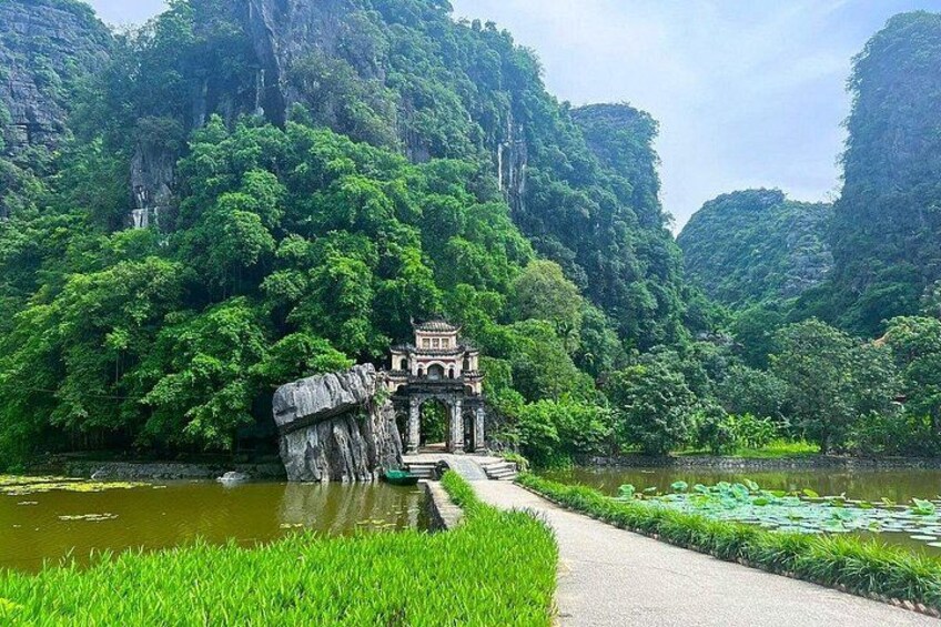 A temple on a rock island surrounded by lush greenery and a calm river. 3