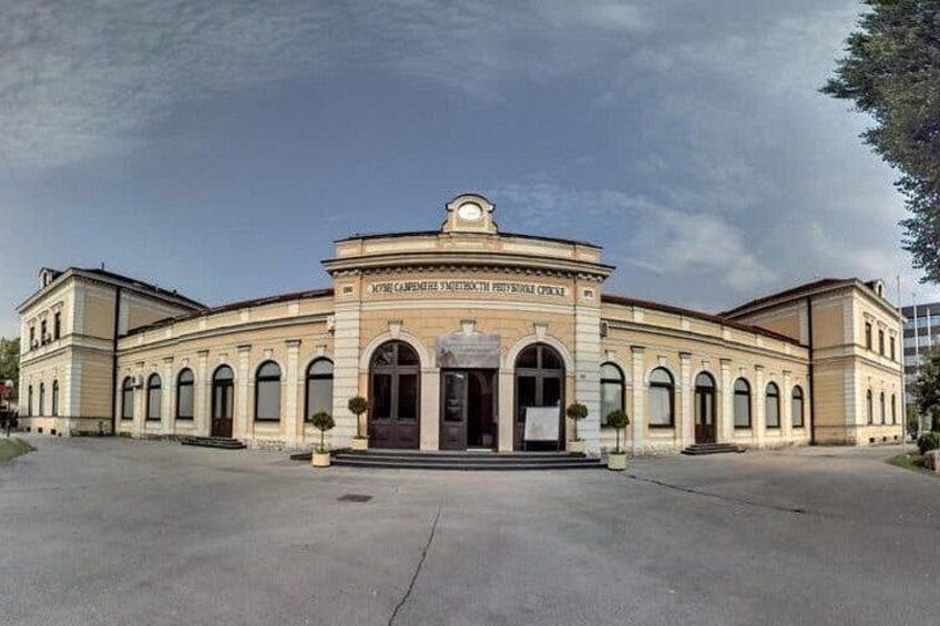 Un edificio grande e histórico con ventanas arqueadas y una entrada central. 4