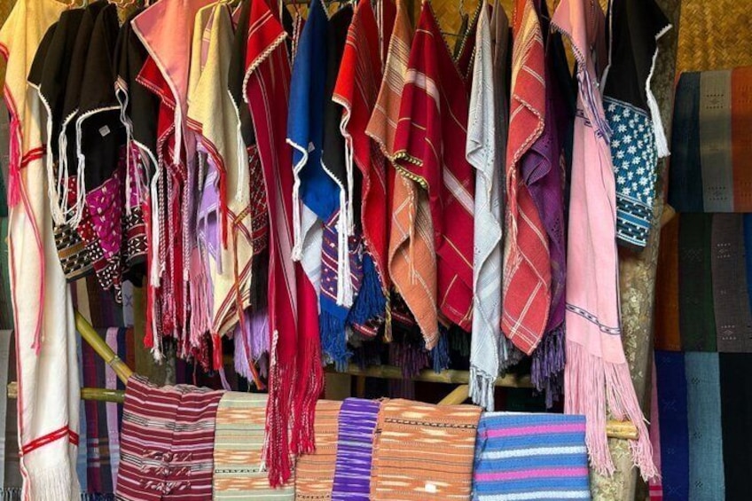 A variety of colorful textiles hanging for sale. 3