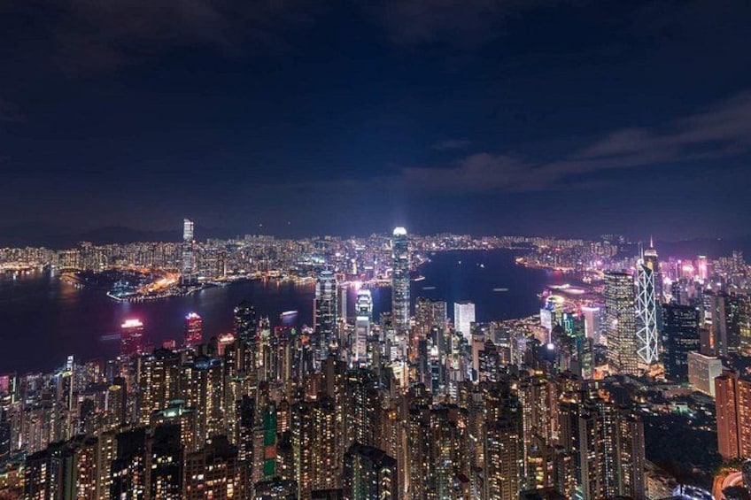 A nighttime cityscape with high-rise buildings, a river, and a bridge. 2