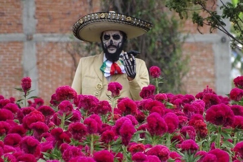 Una persona con un sombrero circondata da fiori rosa vivaci. 4
