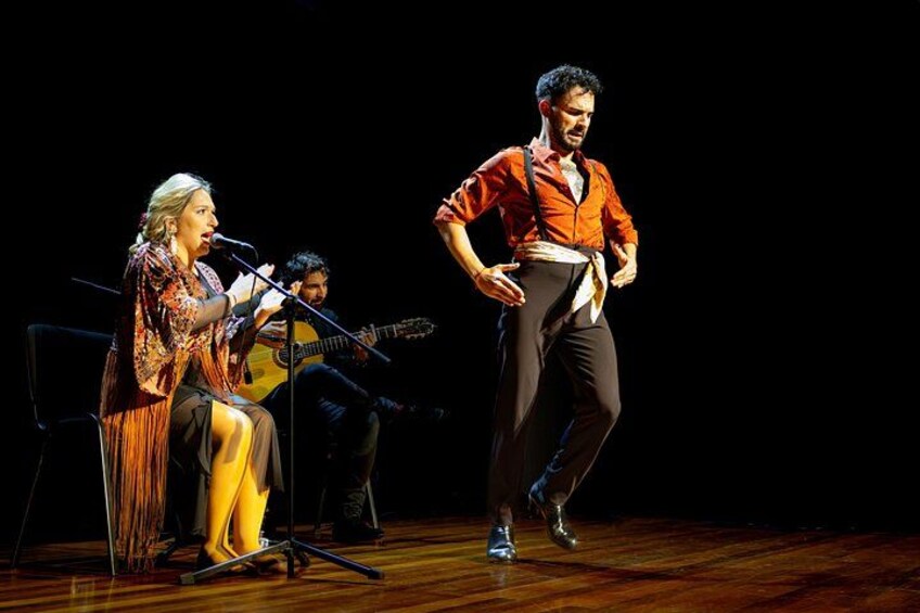 A stage with a singer, a guitarist, and a dancer. 2