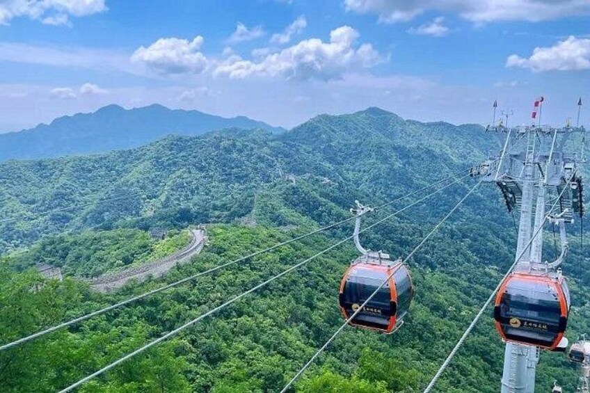 A cable car system with two cars, a mountainous landscape, and a clear sky. 5