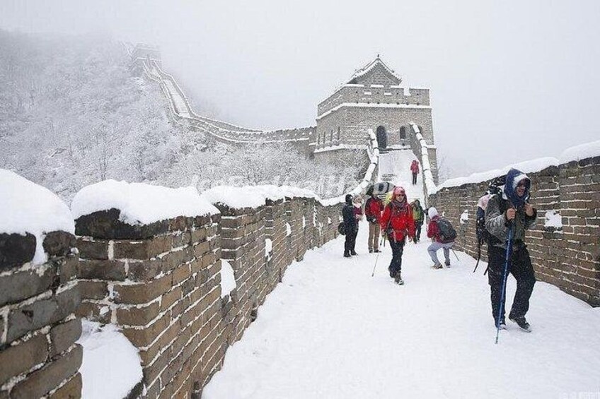 A snow-covered wall with people hiking on it. 2