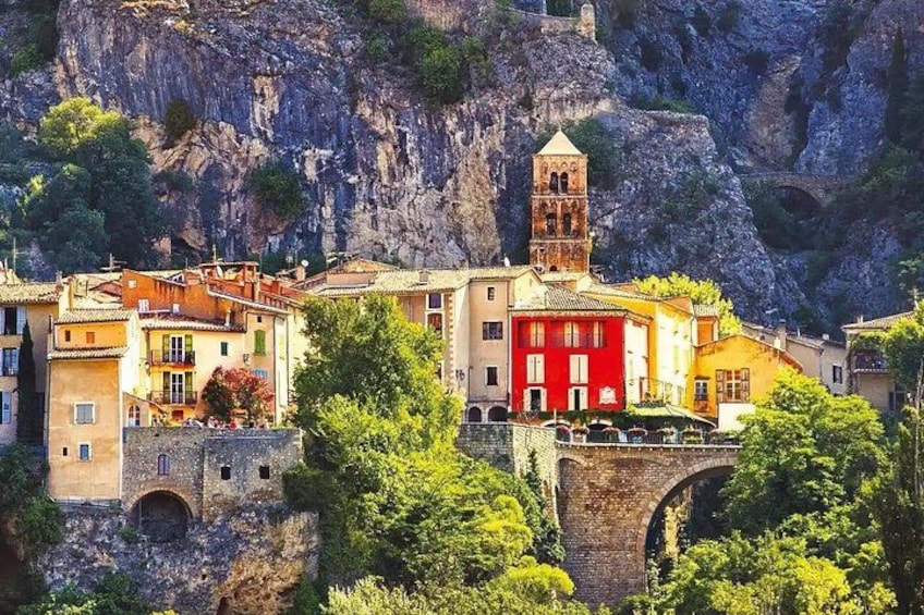A village with colorful buildings, a stone bridge, and a rocky cliff. 4