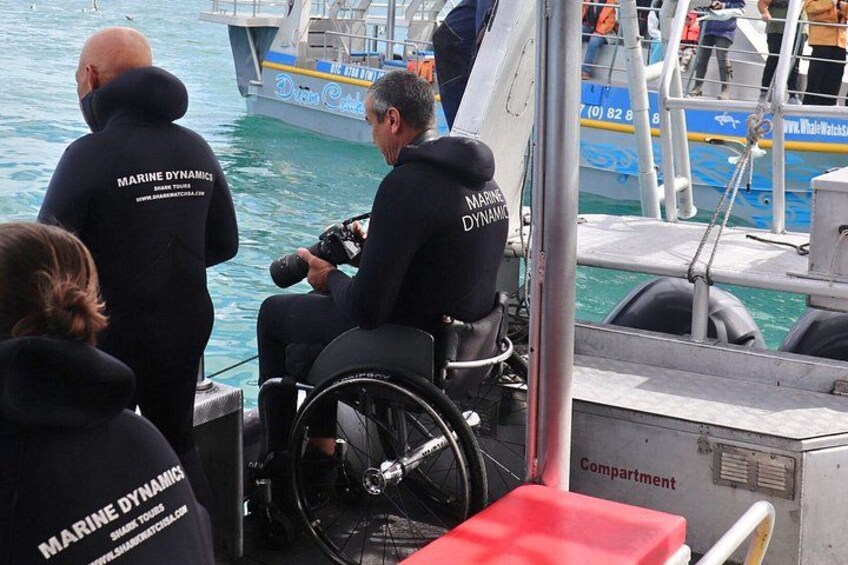 Eine Person im Rollstuhl auf einem Boot, trägt eine Jacke mit dem Aufdruck 'Marine Dynamics'. 3