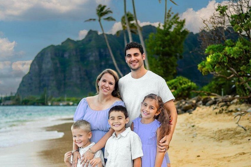 A family on a beach with a mountain in the background. 1