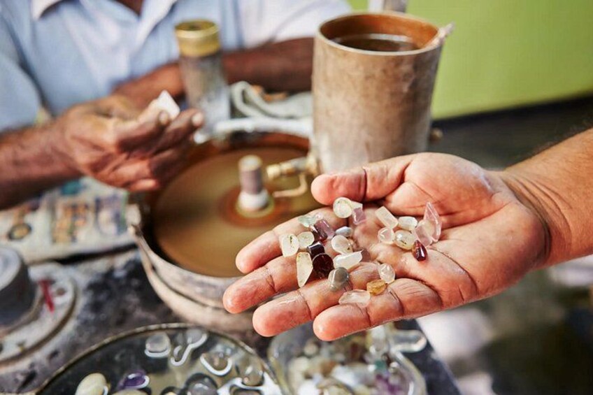 A person holding a bowl of water and a handful of stones. 1