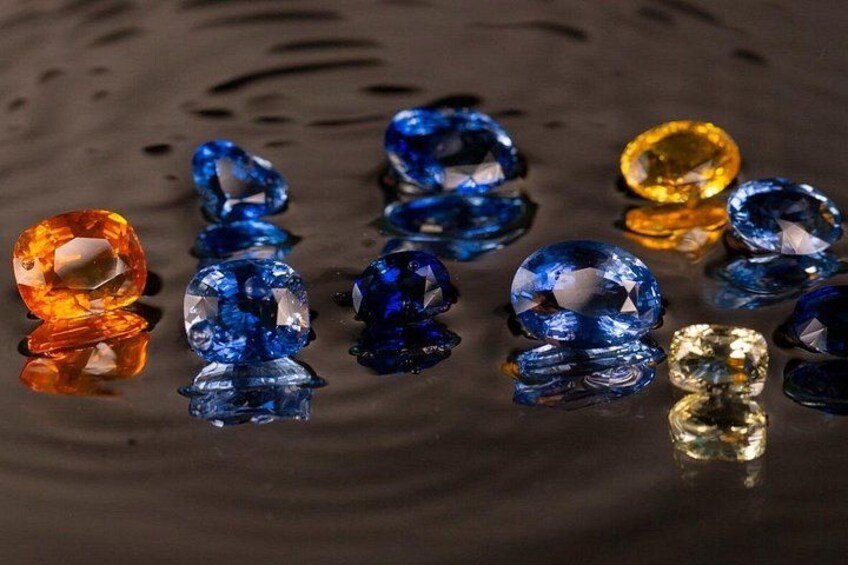 Various colored gemstones on a reflective surface. 2