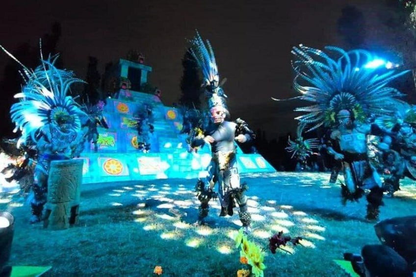 Evento serale all'aperto con artisti in costumi elaborati e penneggiature. 2