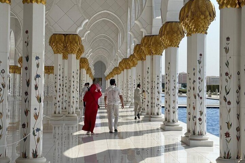 Un vaste espace architectural caractérisé par des colonnes blanches et des décorations dorées. 5