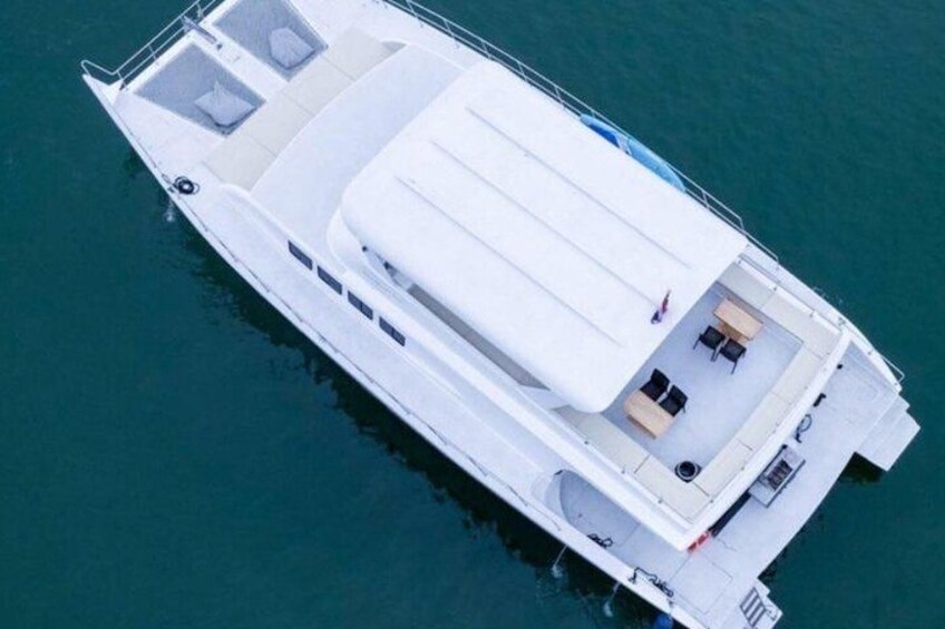 A white boat with a covered deck, windows, and a seating area. 3