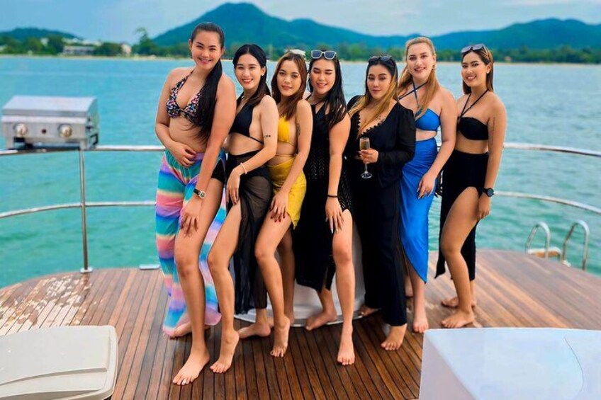 A group of people on a boat with a body of water and mountains in the background. 1