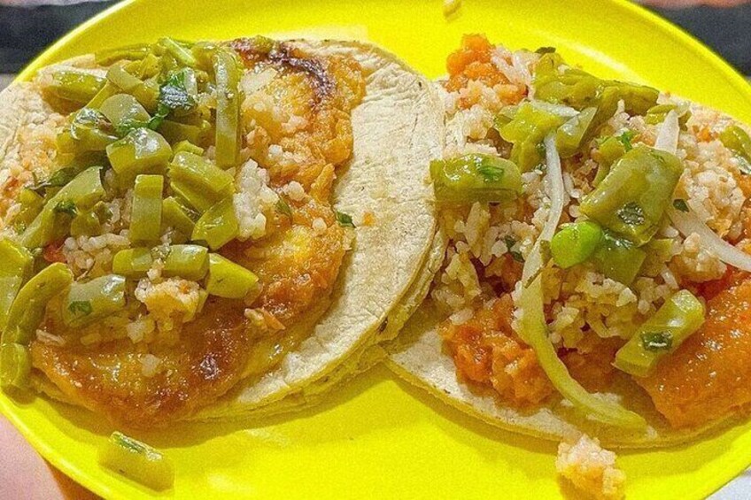 Två tacos på en gul tallrik med gröna paprikor och ris. 3