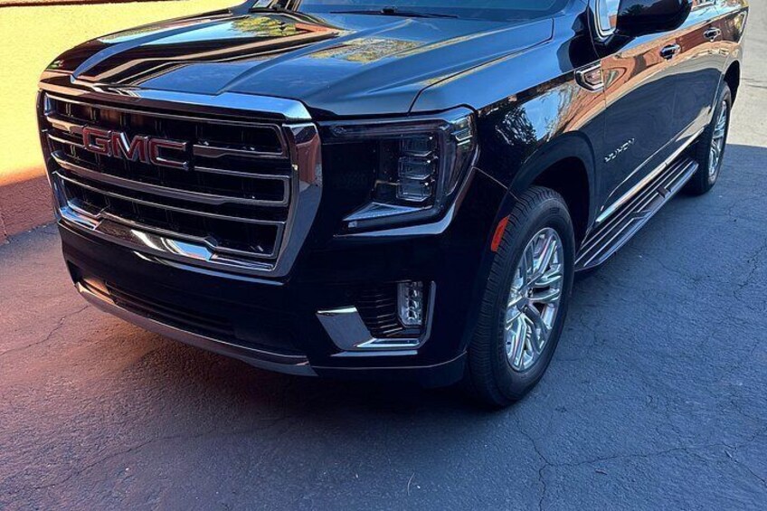 Ein schwarzer GMC SUV auf befestigter Fläche geparkt. 3