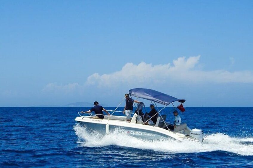 A white speedboat with a canopy, moving swiftly through the ocean. 2