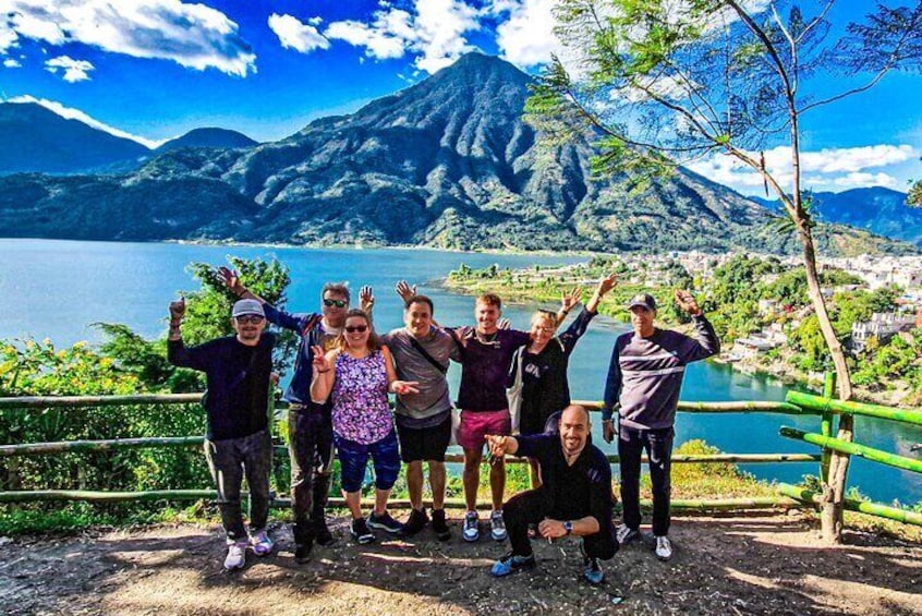Un groupe de personnes posant près d’un lac, avec des montagnes en arrière-plan. 2