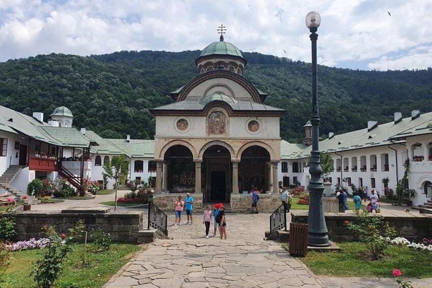 A historical building with a dome, surrounded by a stone pathway and greenery. 4