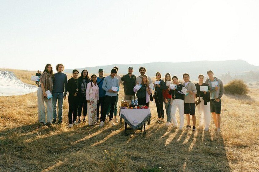 A group of people standing in a field with a table in the center. 3