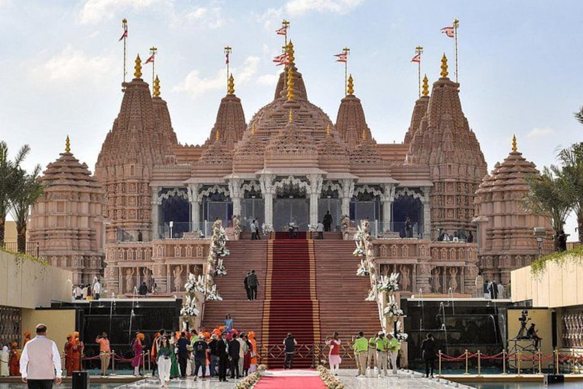 A temple with multiple spires, a central staircase, and a red carpet leading to the entrance. 1