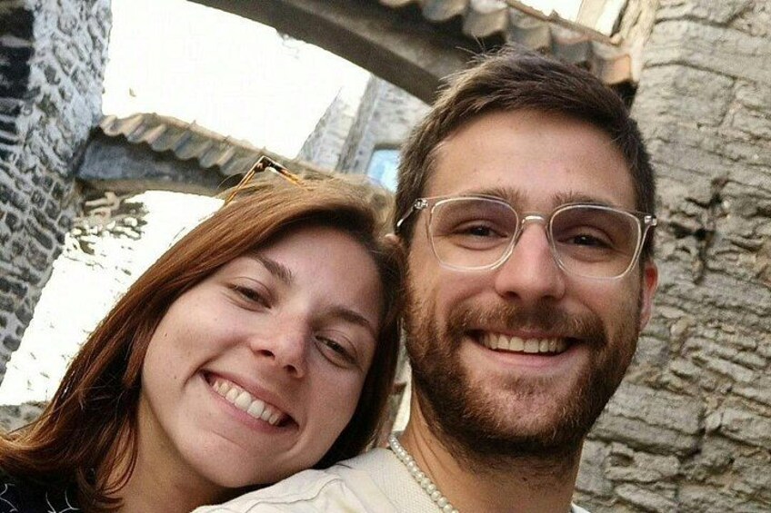 Eine verschwommene Person, eine Steinmauer und ein Gebäude mit einem Ziegeldach. 5