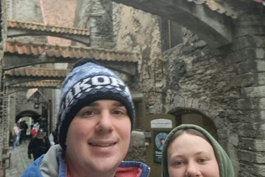 Ein steinernes Torbogen, eine Person mit Mütze und ein Schild mit Text. 2