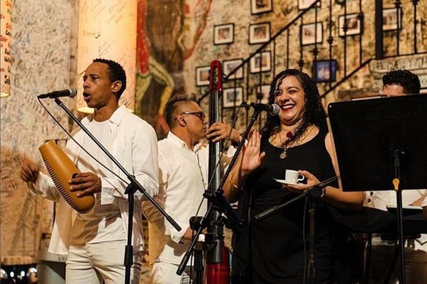 Un grupo de músicos interpretando en un escenario con instrumentos musicales y micrófonos. 3