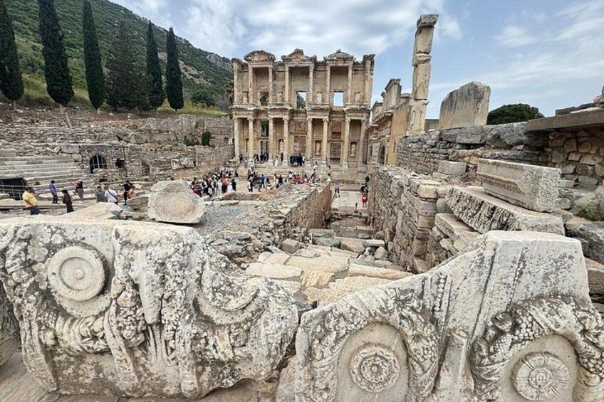 Ancient ruins with a large amphitheater, stone columns, and a partially intact building. 3