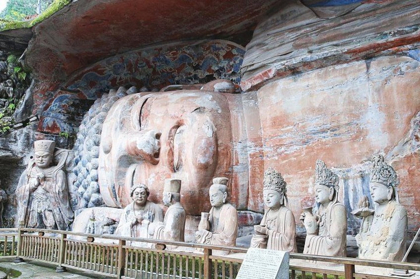A large Buddha statue with smaller figures in front. 1