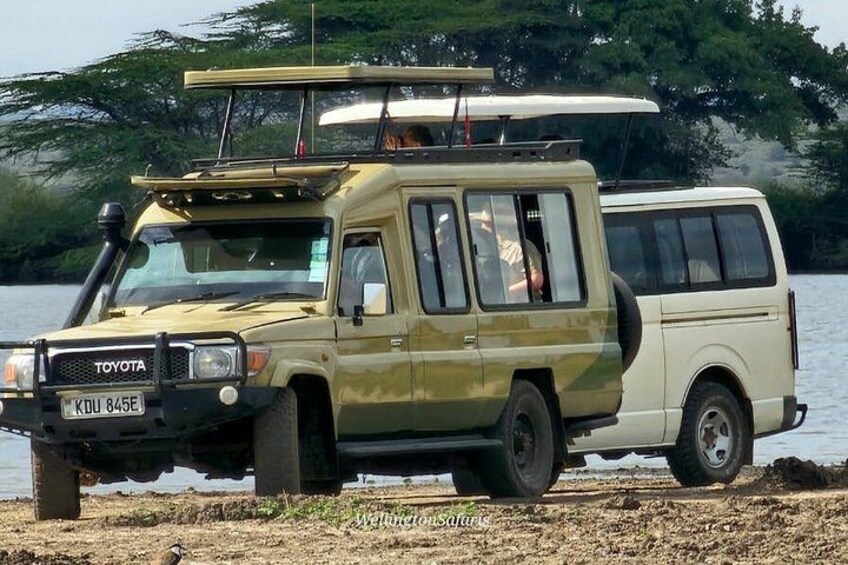 A Toyota Land Cruiser with a roof rack parked by a lake. 1