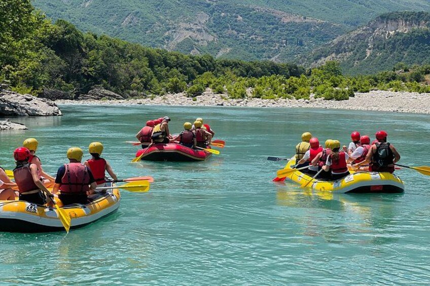 People rafting on a river surrounded by greenery. 3