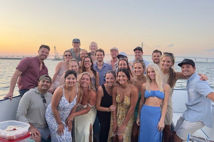A group of people on a boat with a bridge and water in the background. 3