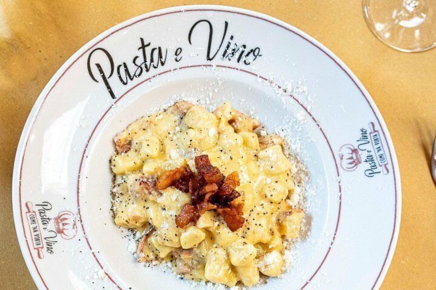 Een bord pasta met spek en kaas, met de tekst 'Pasta e Vino'. 2