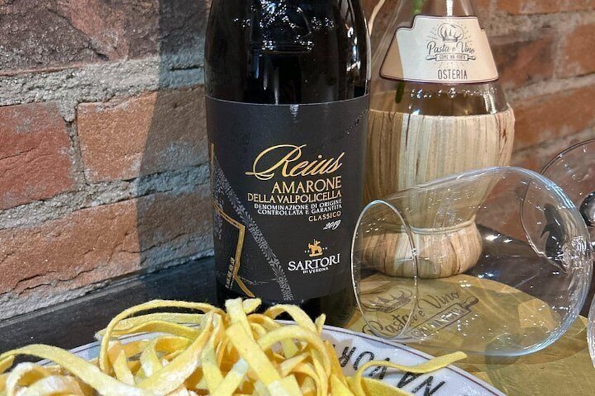 Een fles Amaro Marone, een fles Pasta di Vino en een bord pasta met een vork. 3