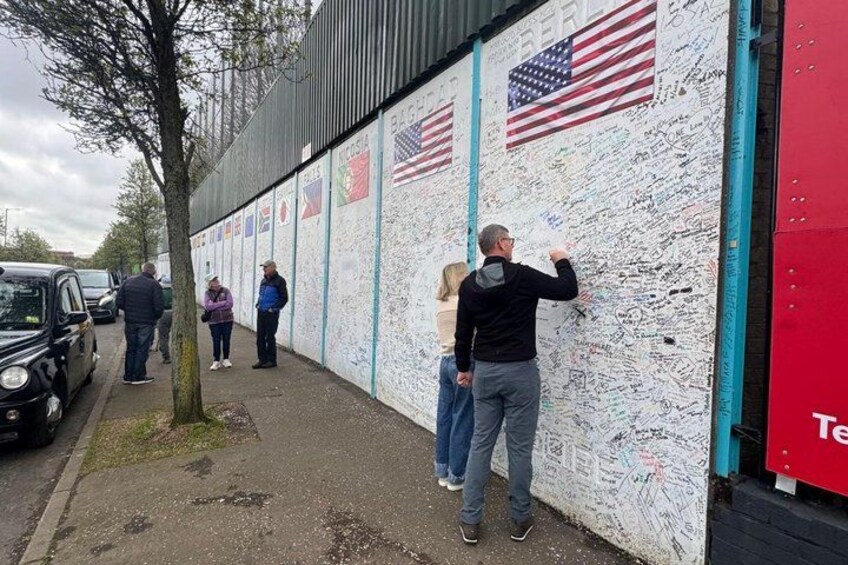 Una pared con varias banderas y firmas. 2