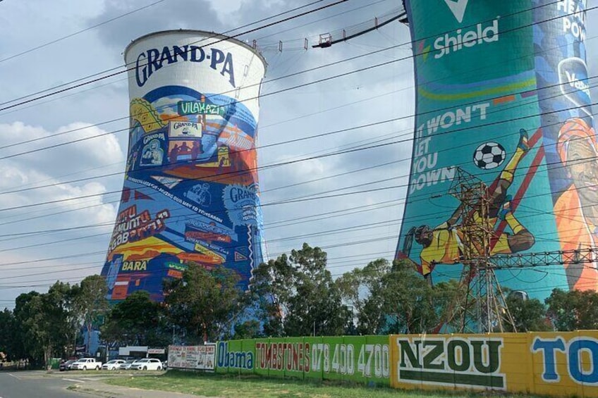 Due grandi torri d'acqua decorate con murales colorati che pubblicizzano diversi marchi e prodotti. 1