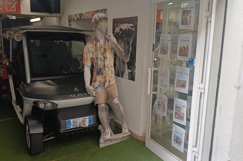 Un carrito de golf, un maniquí y una puerta de cristal con varios carteles. 3