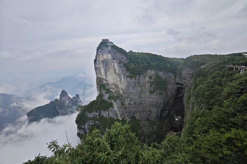 Eine gebirgige Landschaft mit einer markanten Klippe und einer Brücke. 3
