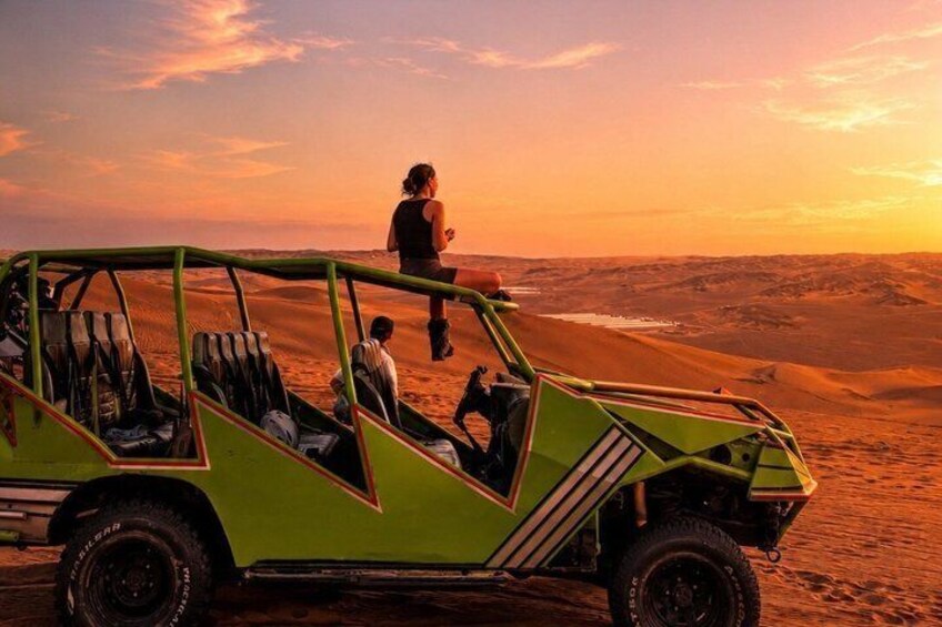 Un vehículo todoterreno verde en un paisaje desértico con un atardecer al fondo. 2