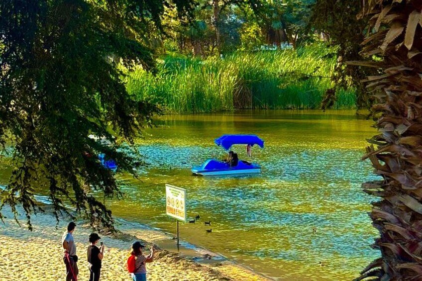 A river with a boat, people on the shore, and a sign. 4